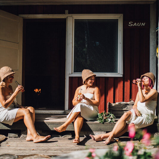 Senni Saun - Inimesed istumas sauna ees seltskonnaüritus - Klaara-Manni Recreation and Seminar Center Senni Sauna - People sitting in front of the sauna at a social event